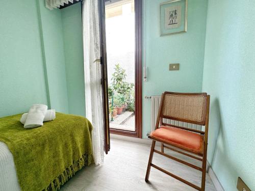 a bedroom with a bed and a chair next to a window at Apartamentos La Caseta in Isla