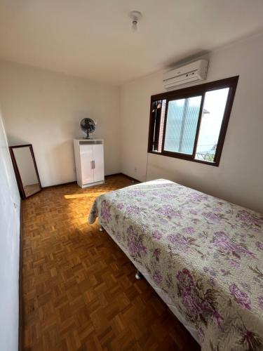 Apto familiar em Cachoeirinha-RS في Cachoeirinha: غرفة نوم بسرير ونافذة