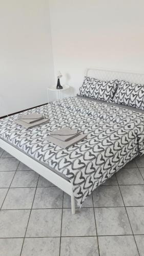- un lit avec une couverture noire et blanche dans l'établissement Appartamento a Lecco sul Lago di Como, à Lecco