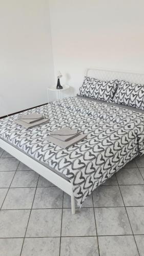 a bed with a black and white blanket on it at Appartamento a Lecco sul Lago di Como in Lecco