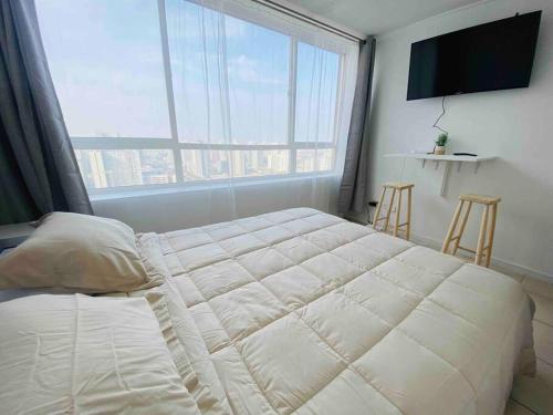a bedroom with a large bed and a large window at Vista Cordillera Studio in Santiago