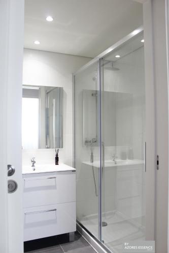 a white bathroom with a shower and a sink at Azores Essence - Coliseu in Ponta Delgada