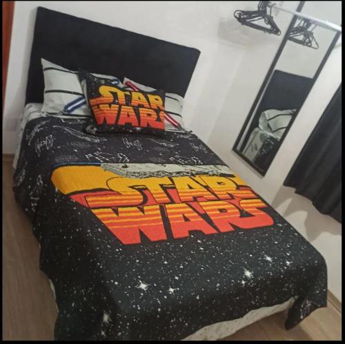 a bed with a star wars comforter in a room at Apt próximo ao Consulado in Porto Alegre
