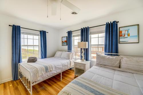 1 dormitorio con 2 camas y cortinas azules en Beachfront Emerald Isle Vacation Rental with Deck! en Emerald Isle