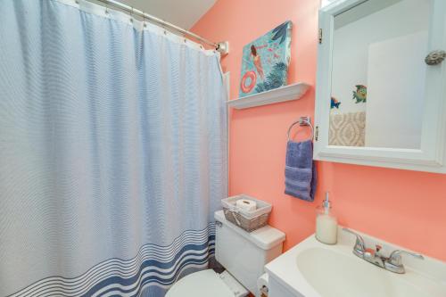 a bathroom with a shower curtain and a toilet at Beachfront Emerald Isle Vacation Rental with Deck! in Emerald Isle