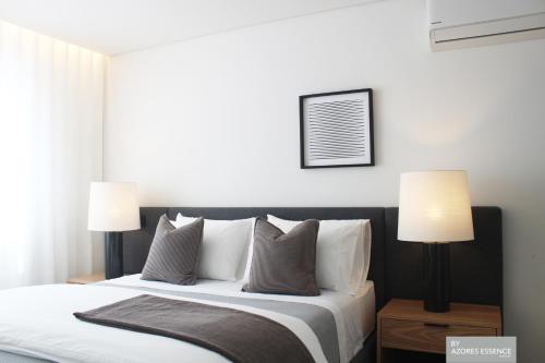 a bedroom with a large bed with two lamps at Azores Essence - Coliseu in Ponta Delgada