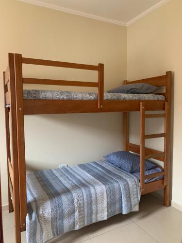 two bunk beds in a room with a bed at Além do Horizonte in Itanhaém