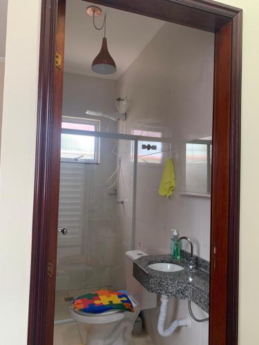 a bathroom with a shower and a sink and a toilet at Além do Horizonte in Itanhaém