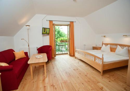 ムルナウ・アム・シュタッフェルゼーにあるSporerhofのベッドと赤いソファのある寝室