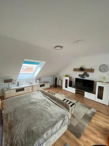 a living room with a bed and a television at Dachgeschoss Apartment mit Ausblick in Halle an der Saale