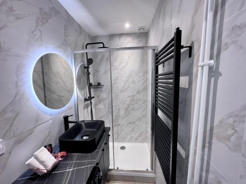 a bathroom with a black sink and a mirror at Paris 18 - 6P - 2BR - Appartement cosy moderne équipé in Paris