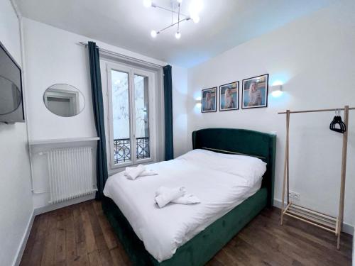 a bedroom with a bed with two towels on it at Paris 18 - 6P - 2BR - Appartement cosy moderne équipé in Paris