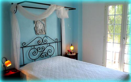 a bedroom with a white bed with a white canopy at Liogerma in Adamas
