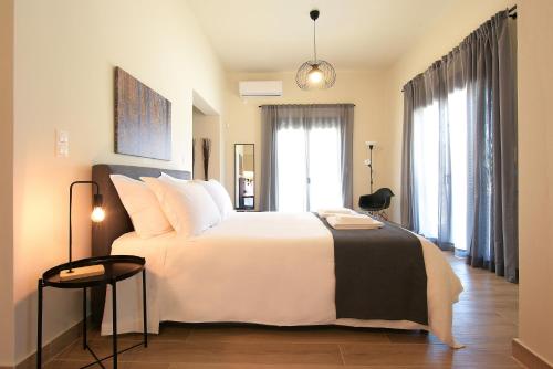 a bedroom with a large white bed with white pillows at Aellō luxury apartments in Markopoulo