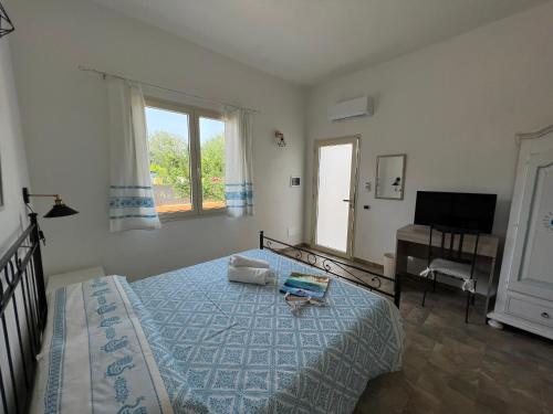 um quarto com uma cama, uma secretária e uma televisão em Casa vacanze Mare Fuori em Capoterra