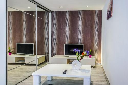 a living room with a white table and two monitors at Alpha loft 1BR apartment in center in Zadar
