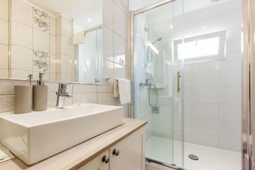 a white bathroom with a sink and a shower at Alpha loft 1BR apartment in center in Zadar