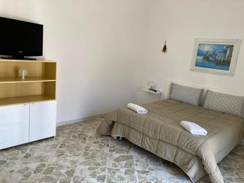 - une chambre avec un lit et une télévision à écran plat dans l'établissement Dimora AnVi, à Bari