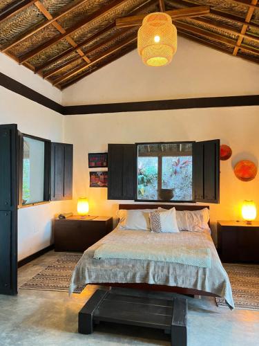 a bedroom with a bed and two lamps and a ceiling at Reserva Natural Tierra Adentro in Minca