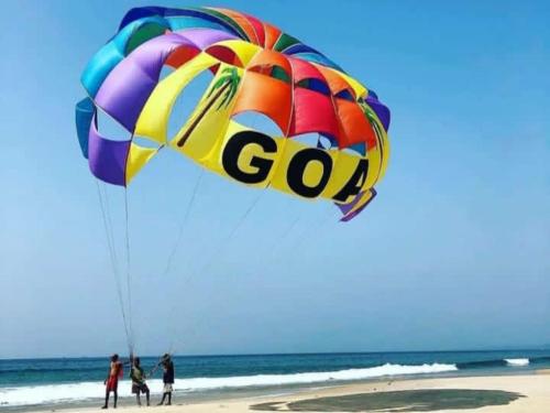 a group of people flying a large kite on the beach at Beach Xaviers Guest House Colva in Colva