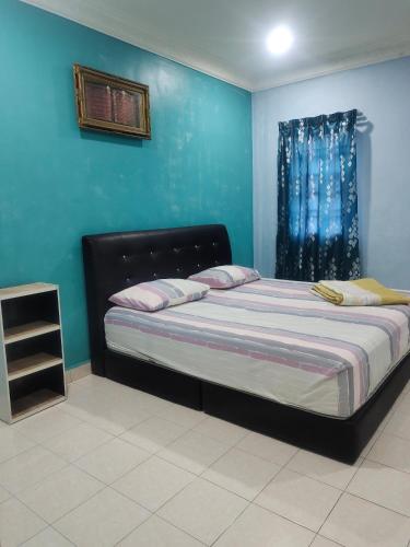 1 dormitorio con 1 cama con pared azul en Homestay Cikgu Zedi Hulu Langat en Hulu Langat