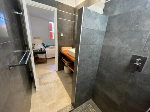 东方湾Villa SUNLIGHT Baie Orientale的带步入式淋浴间和水槽的浴室