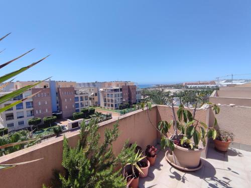 a view of a city from a balcony with plants at Apartamento Ático Laguna Beach Almerimar in Almería