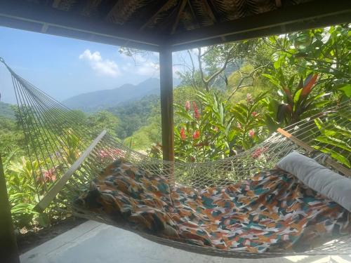 a hammock on a porch with a view of the mountains at Reserva Natural Tierra Adentro in Minca