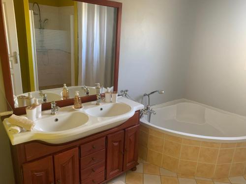 W łazience znajduje się wanna, umywalka i wanna. w obiekcie Belle maison de vacance avec piscine w mieście Ménesplet