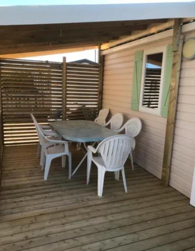 une table et des chaises assises sur une terrasse dans l'établissement Mobile Home tout confort climatisé 4 à 6 personnes Camping Les Salins de la Gardiole ancien camping de L'Europe à Vic La Gardiole, à Vic-la-Gardiole