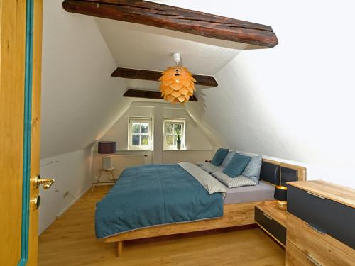 a bedroom with a bed with blue sheets and a ceiling at Loft am Malerweg in Reinhardtsdorf