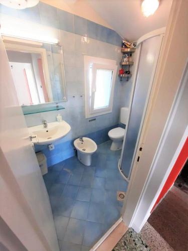 a bathroom with two sinks and a toilet and a mirror at Villa Wanda 2 in Bibione