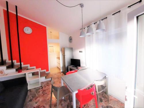 una sala da pranzo con tavolo e parete rossa di Villa Wanda 2 a Bibione