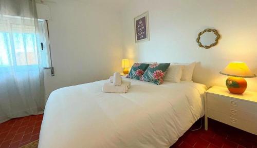 a bedroom with a large white bed with a night stand at Ria Beach House in Faro