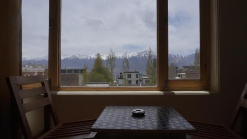 a view of a window with a table and a bowl at 16 ARAHAT GUEST HOUSE in Leh