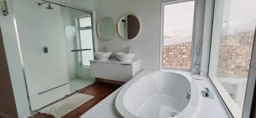 a bathroom with a large white tub and a sink at Sunbay in Hentiesbaai