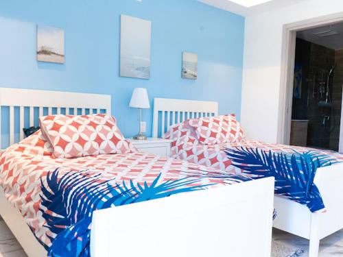 a bedroom with two beds and a blue wall at Exclusive brand new 3BR condo at Cap Cana in Punta Cana