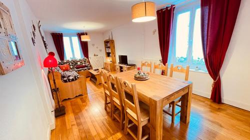 uma cozinha e sala de jantar com uma mesa de madeira e cadeiras em L'Ecureuil em Gérardmer