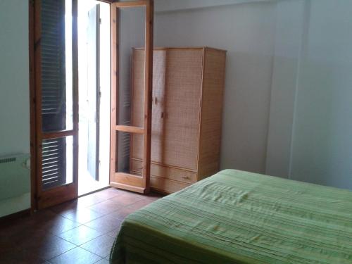 a bedroom with a bed and a dresser and a window at Appartamento a Marina di Campo in Marina di Campo