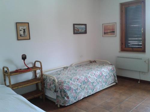 a bedroom with a bed and a table and a window at Appartamento a Marina di Campo in Marina di Campo