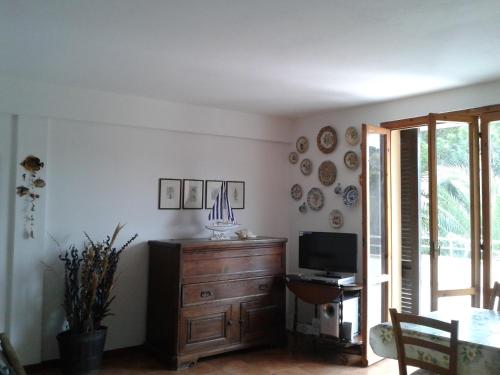 a living room with a television and a wooden dresser at Appartamento a Marina di Campo in Marina di Campo