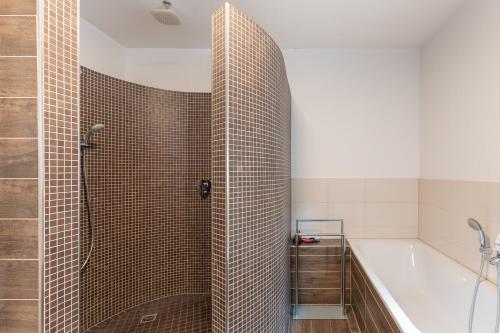 a bathroom with a shower and a tub and a sink at Windrose in Drelsdorf