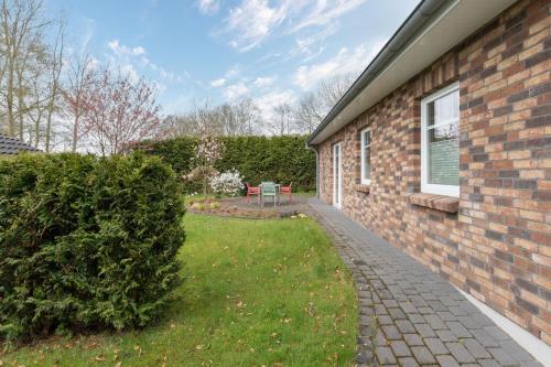 a brick house with a grass yard next to a building at Windrose in Drelsdorf