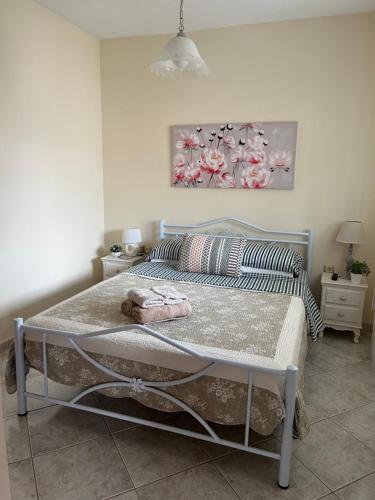 a bed in a bedroom with a painting on the wall at Apartment Efi in N&eacute;a P&eacute;ramos