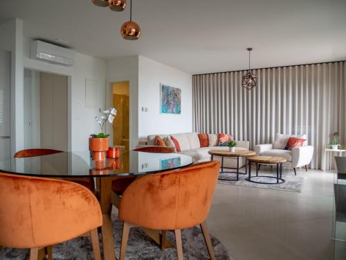 a living room with a glass table and orange chairs at Grand Amore Apartment in Dubrovnik
