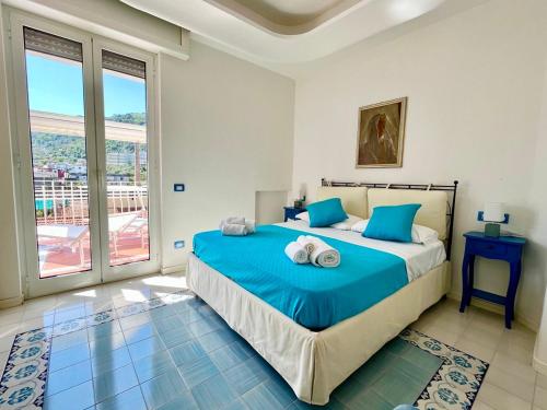 Schlafzimmer mit einem Bett mit blauer Bettwäsche und einem Fenster in der Unterkunft La Casa di Terry - Breathtaking view of Sorrento in Sorrent