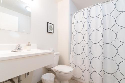 a bathroom with a toilet and a shower curtain at Westover Inn in Saint Marys