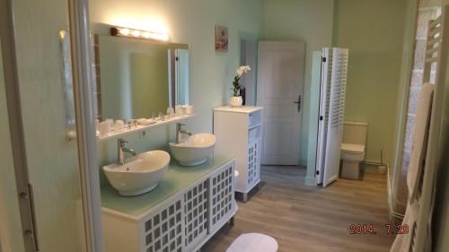 une salle de bain avec deux lavabos et un miroir dans l'établissement Domaine de Nalou, à Saint-Geniez-ô-Merle