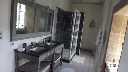 une salle de bain avec un lavabo noir et un miroir dans l'établissement Domaine de Nalou, à Saint-Geniez-ô-Merle