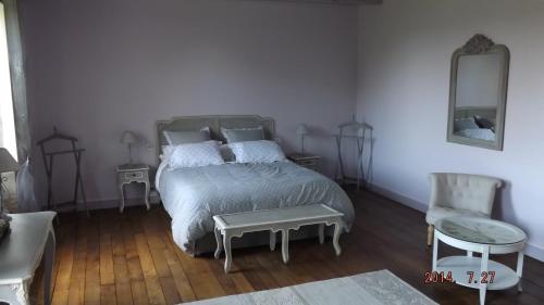 1 Schlafzimmer mit einem Bett, 2 Stühlen und einem Spiegel in der Unterkunft Domaine de Nalou 